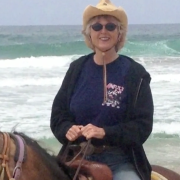 woman riding horse with ocean in the background